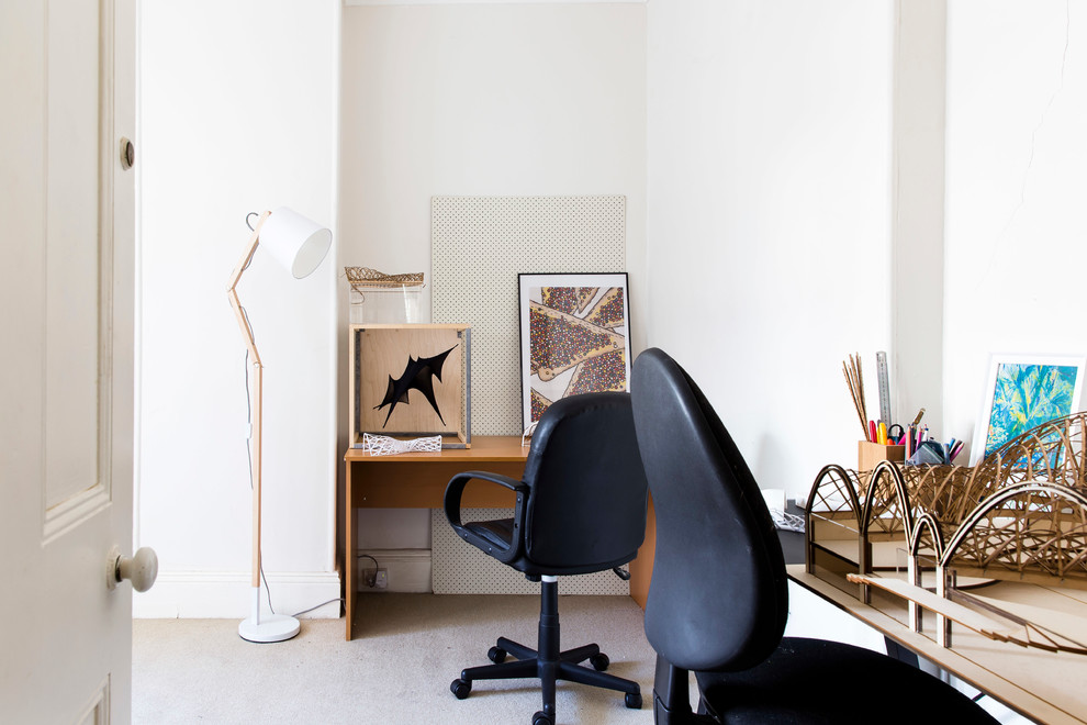 На фото: кабинет в скандинавском стиле с белыми стенами и отдельно стоящим рабочим столом с