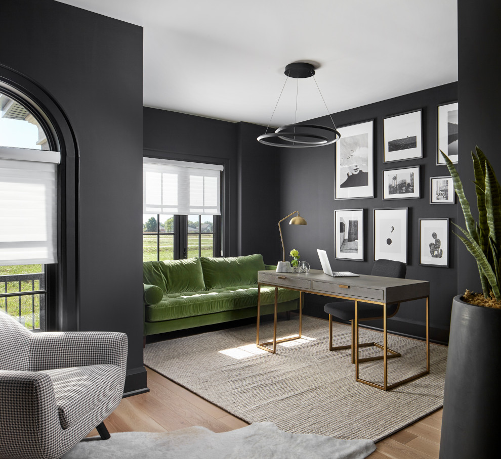 Cette image montre un grand bureau design avec un mur noir, parquet clair, un bureau indépendant et un sol beige.