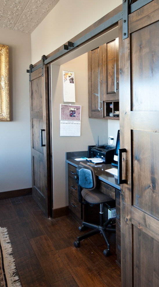 Immagine di un piccolo studio stile rurale con scrivania autoportante e pavimento in legno massello medio
