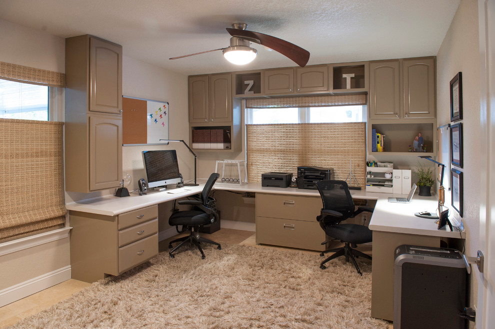 Example of a large trendy freestanding desk travertine floor study room design in Atlanta with beige walls