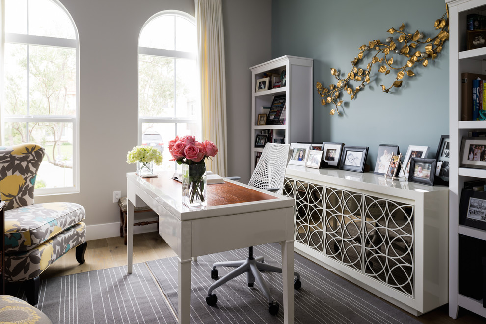 Diseño de despacho clásico con paredes azules, suelo de madera clara y escritorio independiente
