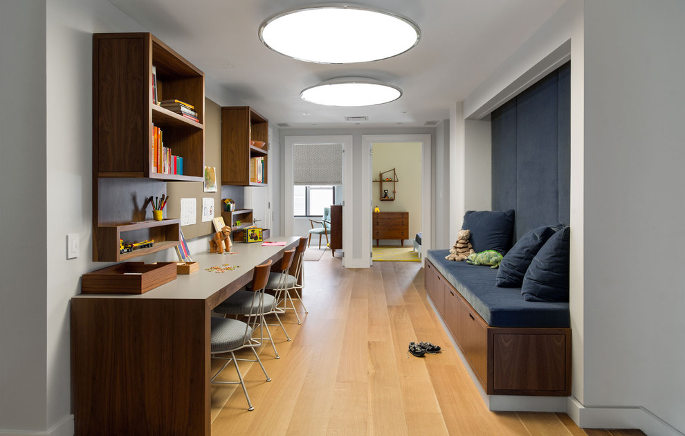 Modernes Arbeitszimmer mit weißer Wandfarbe, freistehendem Schreibtisch und hellem Holzboden in New York