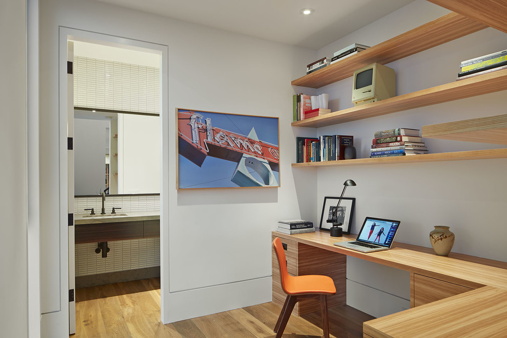 Inspiration pour un bureau design avec un mur blanc, un sol en bois brun et un bureau intégré.