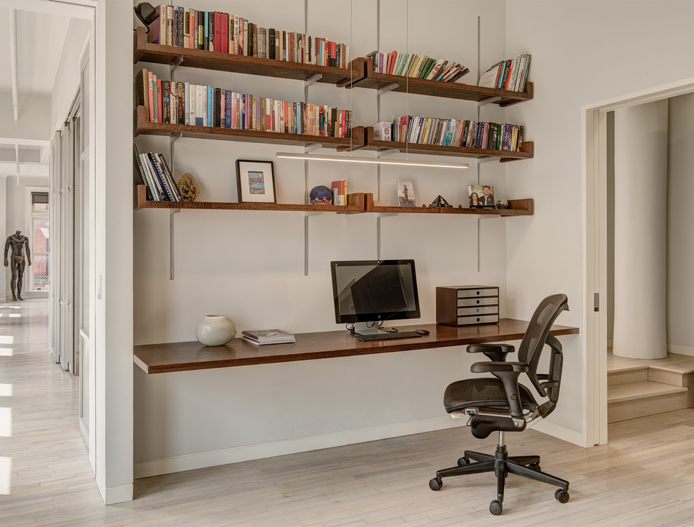 Modernes Arbeitszimmer mit hellem Holzboden, Einbau-Schreibtisch, grauer Wandfarbe und beigem Boden in New York