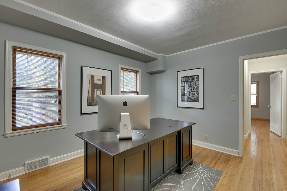 Design ideas for a medium sized contemporary study in Minneapolis with grey walls, light hardwood flooring, no fireplace and a freestanding desk.