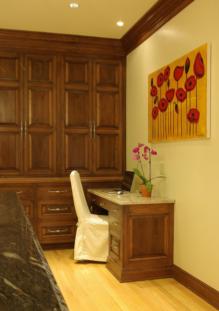 Пример оригинального дизайна: кабинет среднего размера в классическом стиле с желтыми стенами, светлым паркетным полом и встроенным рабочим столом без камина