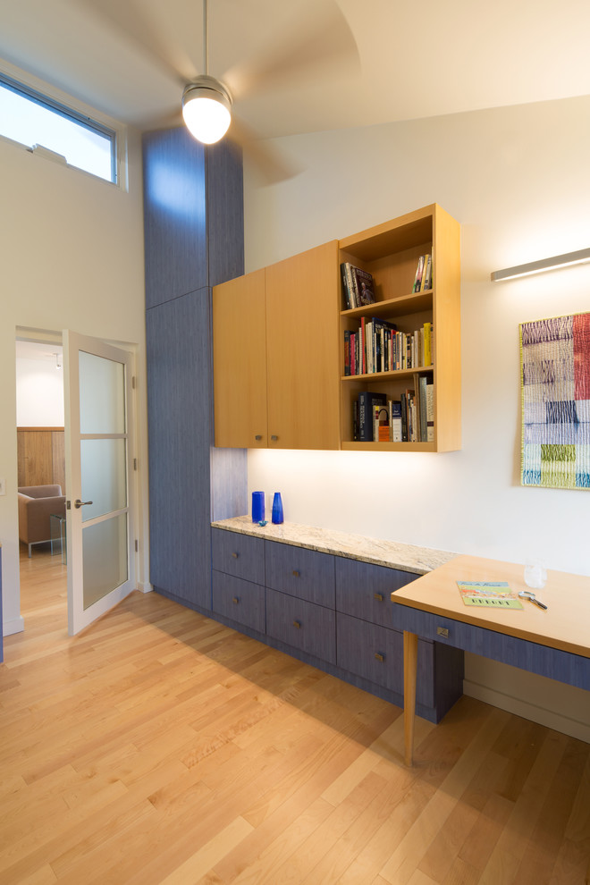 Mid-sized trendy built-in desk light wood floor home office photo in DC Metro with white walls