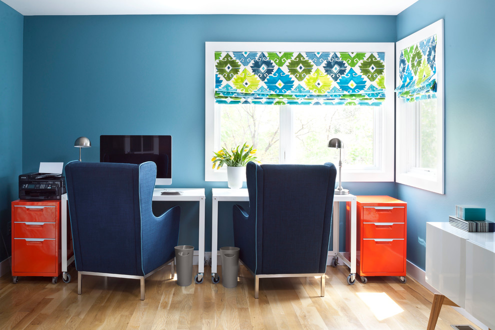 Modelo de despacho pequeño con paredes azules, suelo de madera en tonos medios y escritorio independiente