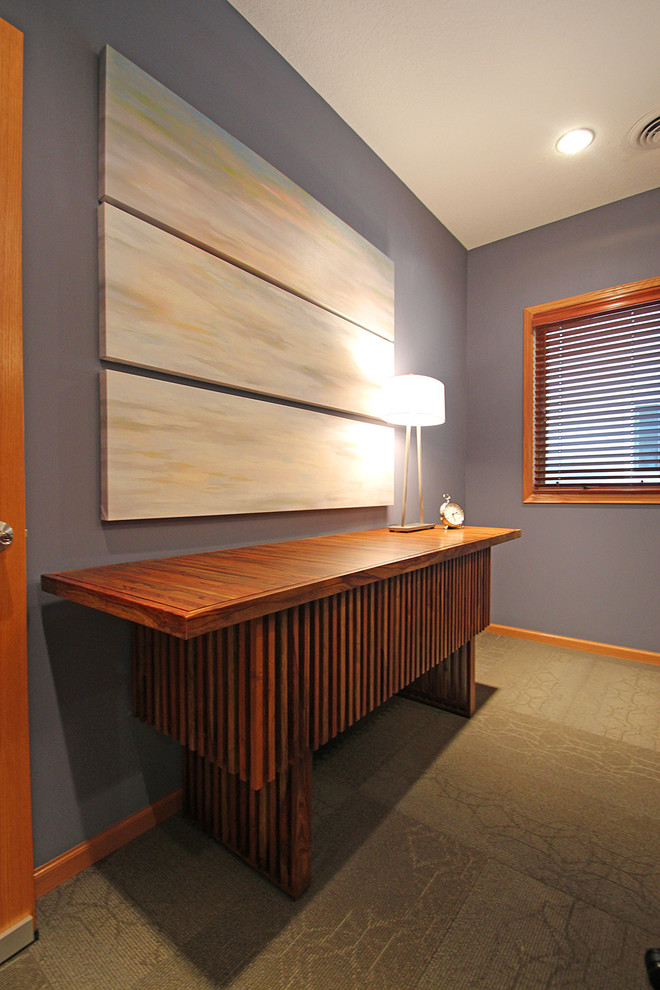 Modelo de despacho contemporáneo de tamaño medio sin chimenea con paredes azules, moqueta y escritorio independiente