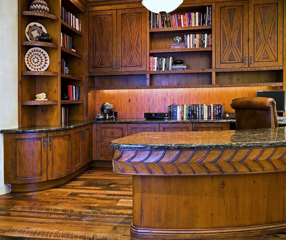 Imagen de despacho de estilo americano extra grande sin chimenea con paredes blancas, suelo de madera oscura, escritorio empotrado y suelo marrón