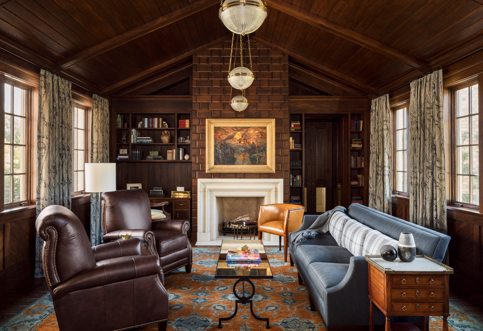 ミルウォーキーにある高級な広いトラディショナルスタイルのおしゃれな書斎 (茶色い壁、カーペット敷き、造り付け机、マルチカラーの床、標準型暖炉) の写真