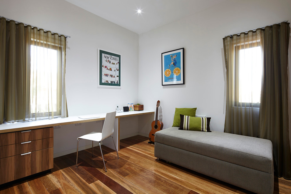Immagine di un ufficio minimal con pareti bianche, pavimento in legno massello medio, nessun camino e scrivania incassata