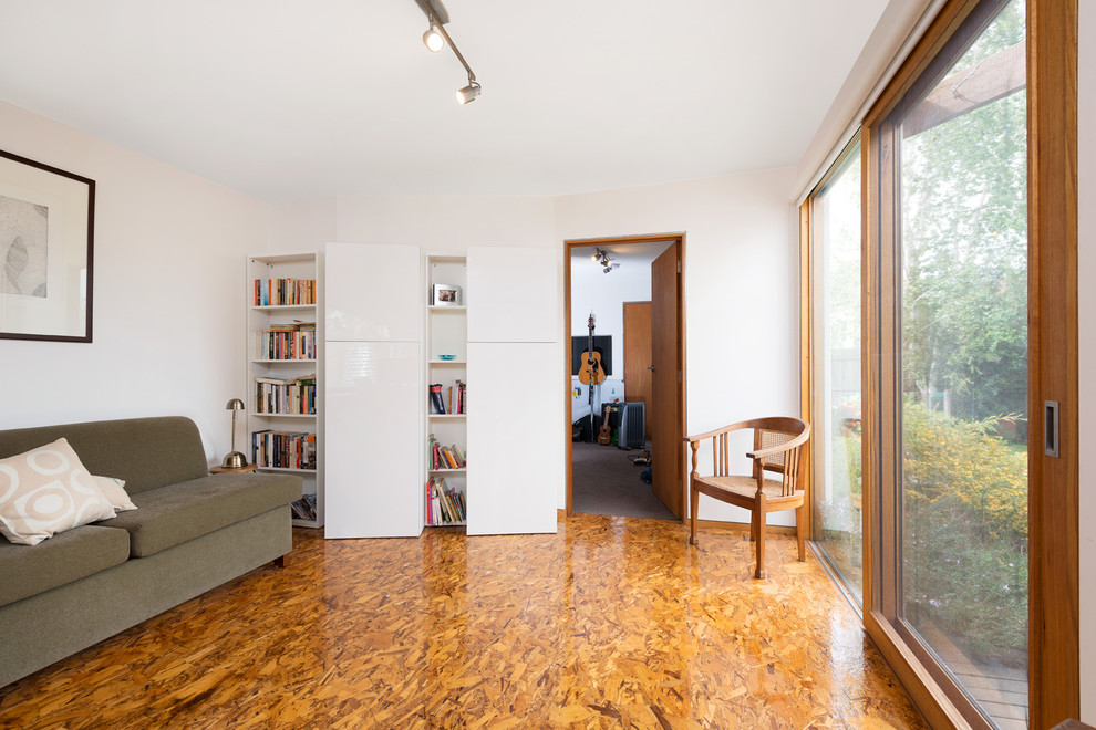 Modernes Arbeitszimmer mit weißer Wandfarbe und braunem Boden in Melbourne