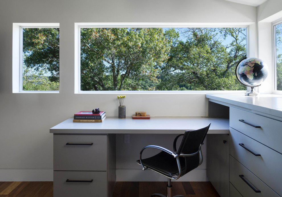 Inspiration for a contemporary home office in Austin with white walls, dark hardwood flooring and a built-in desk.