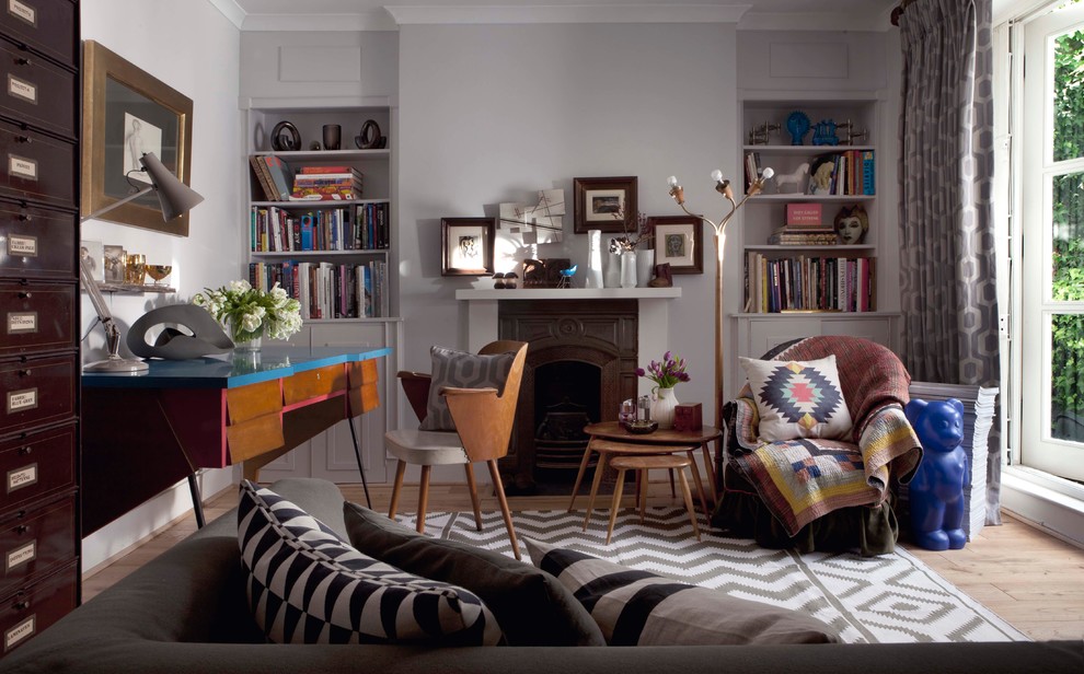 Exempel på ett mellanstort eklektiskt arbetsrum, med grå väggar, ljust trägolv, en standard öppen spis, en spiselkrans i trä och ett fristående skrivbord