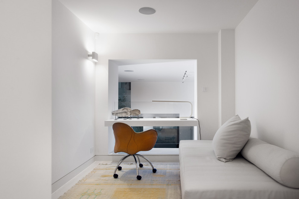 Diseño de despacho actual de tamaño medio con paredes blancas y escritorio empotrado