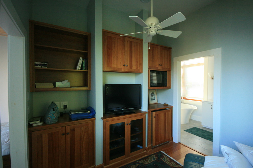 Cette photo montre un petit bureau craftsman avec un mur vert, un sol en bois brun, aucune cheminée et un bureau indépendant.