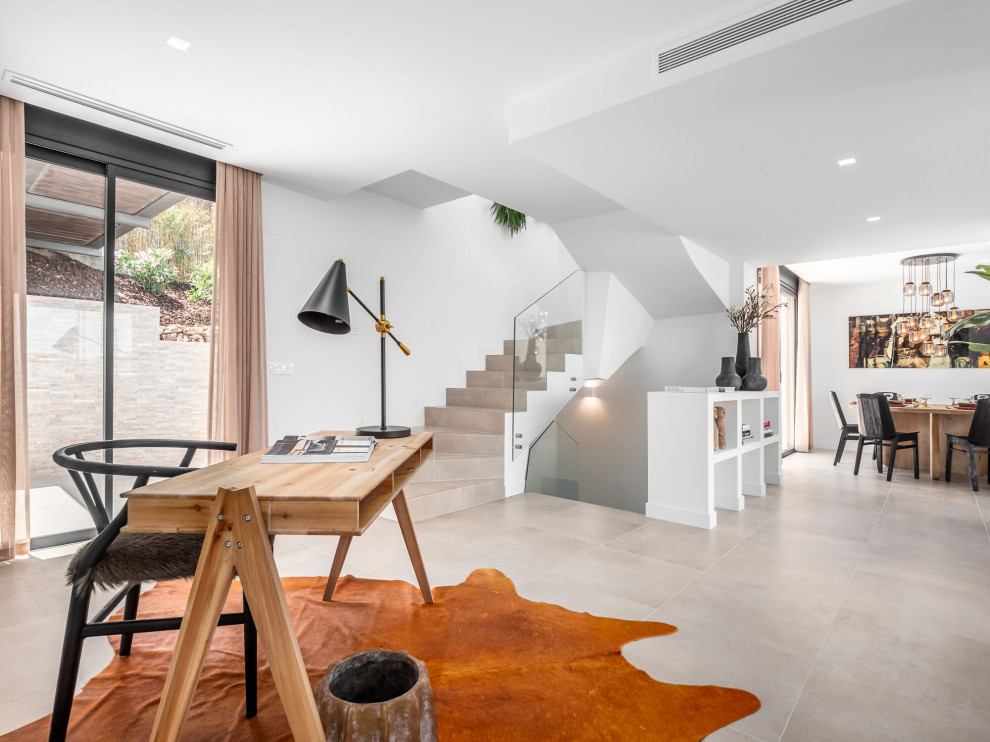 Diseño de despacho mediterráneo sin chimenea con paredes blancas, escritorio independiente y suelo beige