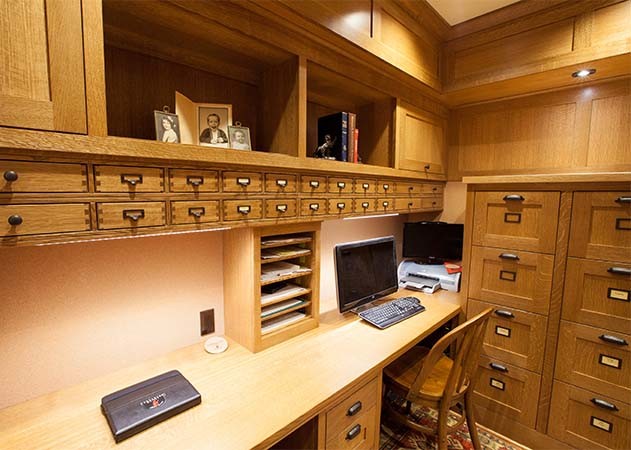 Exempel på ett mellanstort amerikanskt arbetsrum, med ett bibliotek, bruna väggar, ljust trägolv, ett fristående skrivbord och brunt golv