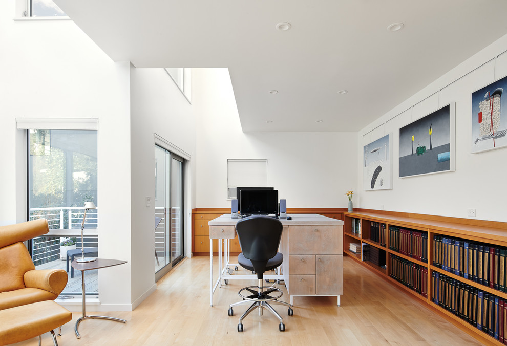 Modelo de despacho contemporáneo con paredes blancas, suelo de madera clara, escritorio independiente y suelo beige