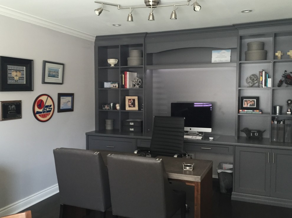 Large contemporary study in Toronto with grey walls, dark hardwood flooring, no fireplace and a built-in desk.