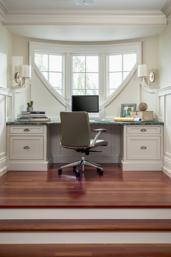 Elegant built-in desk dark wood floor home office photo in Toronto with beige walls