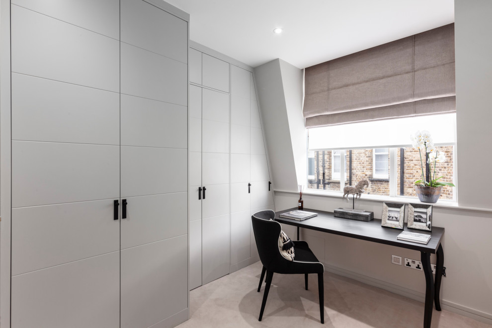 Mittelgroßes Modernes Arbeitszimmer mit Arbeitsplatz, grauer Wandfarbe, Teppichboden, freistehendem Schreibtisch und grauem Boden in London