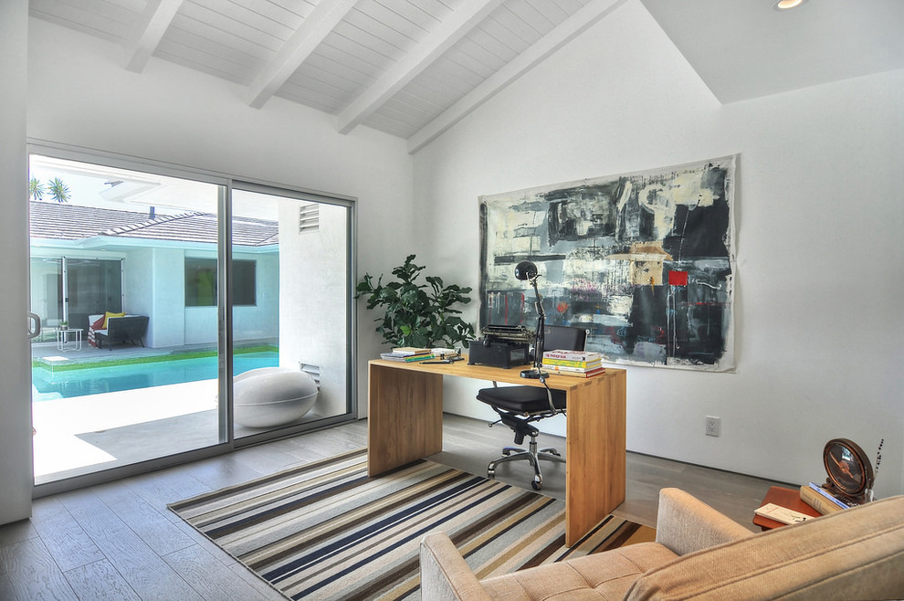 Exempel på ett modernt arbetsrum, med vita väggar, mörkt trägolv och ett fristående skrivbord