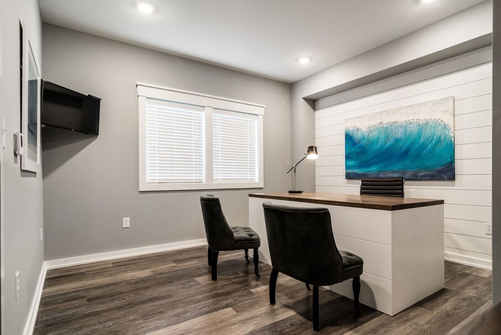 This is an example of a small contemporary study in Other with grey walls, dark hardwood flooring, no fireplace, a freestanding desk and brown floors.
