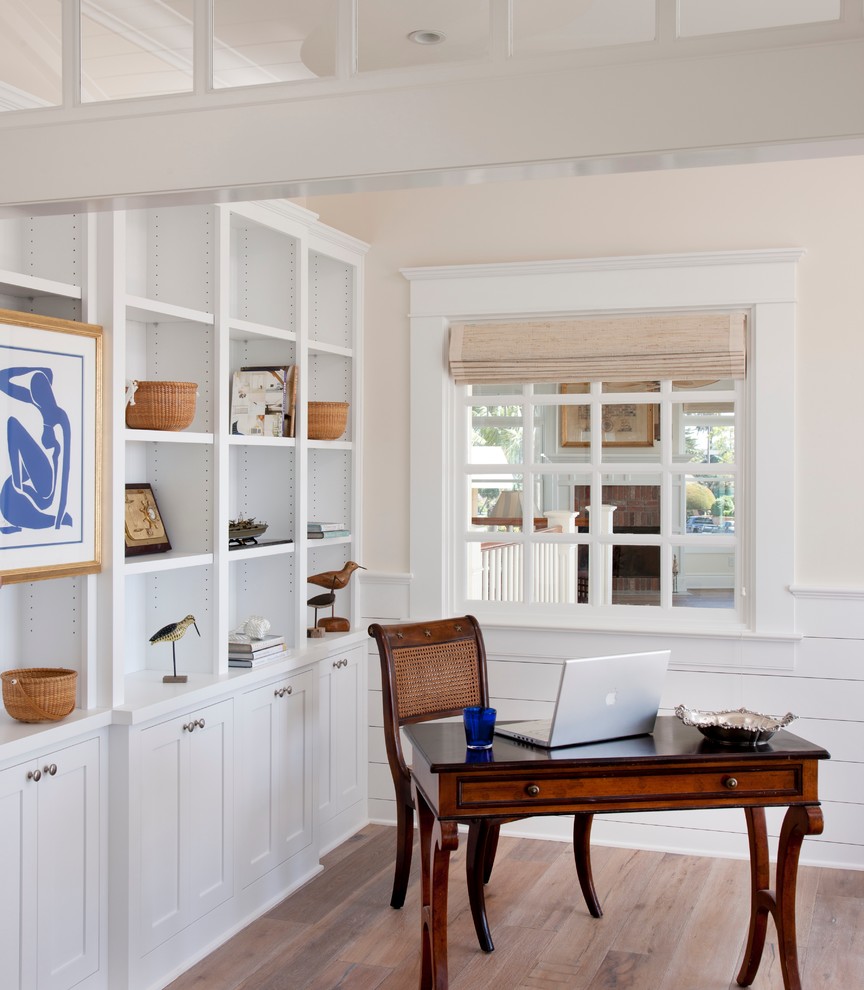 Inspiration for a coastal study in San Diego with beige walls, light hardwood flooring, a freestanding desk and beige floors.