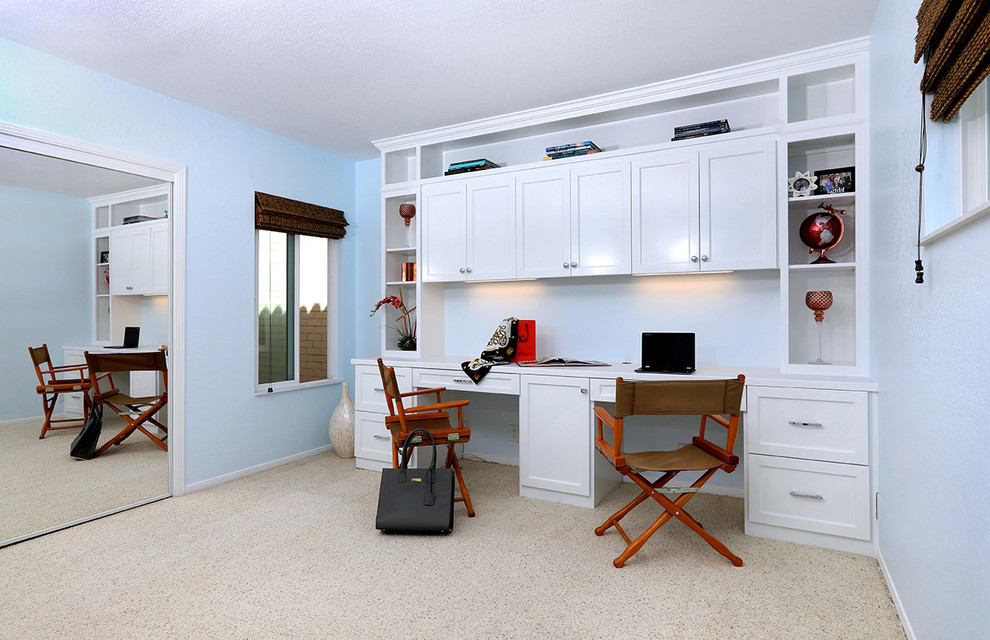 Example of a beach style built-in desk carpeted and beige floor study room design in San Diego with blue walls and no fireplace