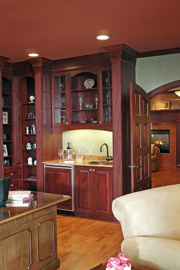 Diseño de despacho clásico con paredes beige, suelo de madera en tonos medios y escritorio independiente