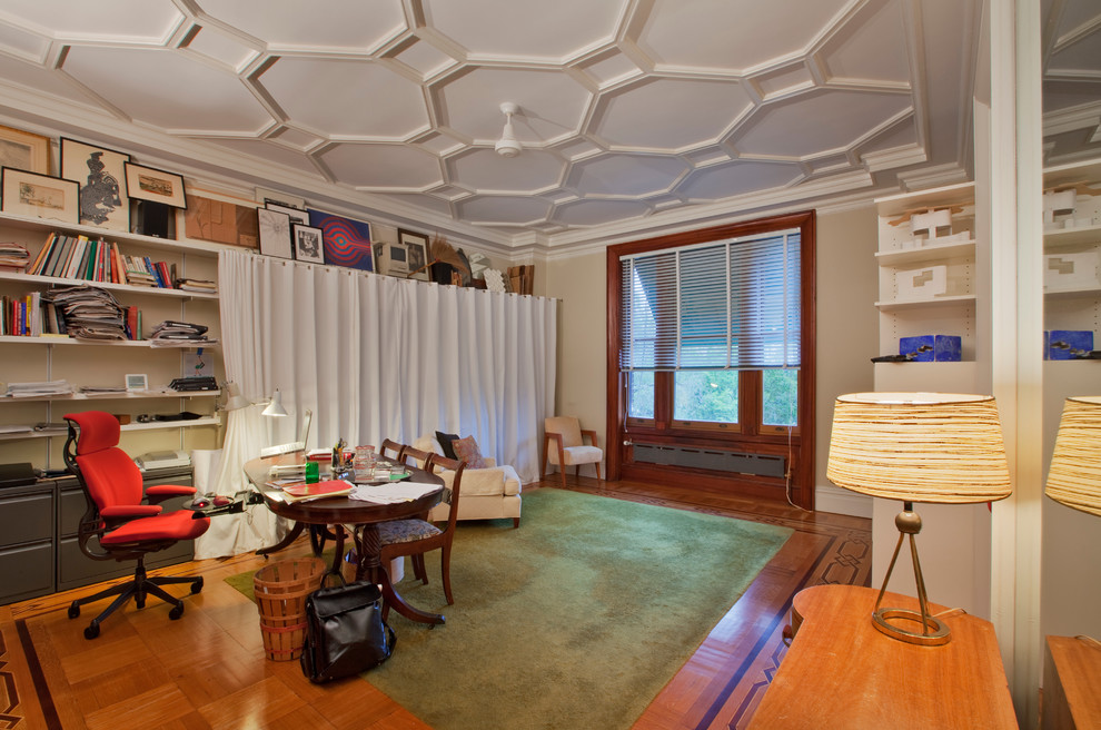 Diseño de estudio minimalista grande con paredes beige, suelo de madera clara y escritorio independiente