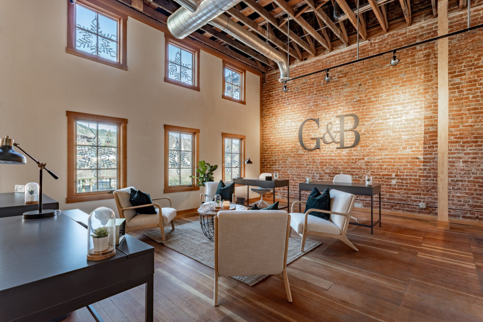 Diseño de despacho abovedado contemporáneo de tamaño medio sin chimenea con paredes rojas, suelo de madera en tonos medios, escritorio independiente, suelo marrón y ladrillo