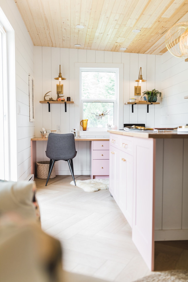 Réalisation d'un petit bureau atelier champêtre avec un mur blanc, un sol en vinyl, un bureau intégré, un plafond en bois, du lambris de bois et un sol marron.