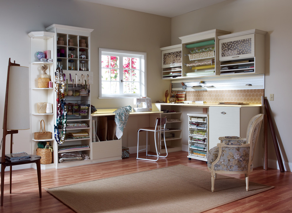 Exempel på ett mellanstort modernt hobbyrum, med beige väggar, ljust trägolv, ett inbyggt skrivbord och brunt golv