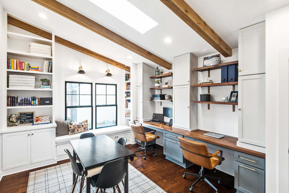Inredning av ett lantligt arbetsrum, med vita väggar, mörkt trägolv, ett inbyggt skrivbord och brunt golv
