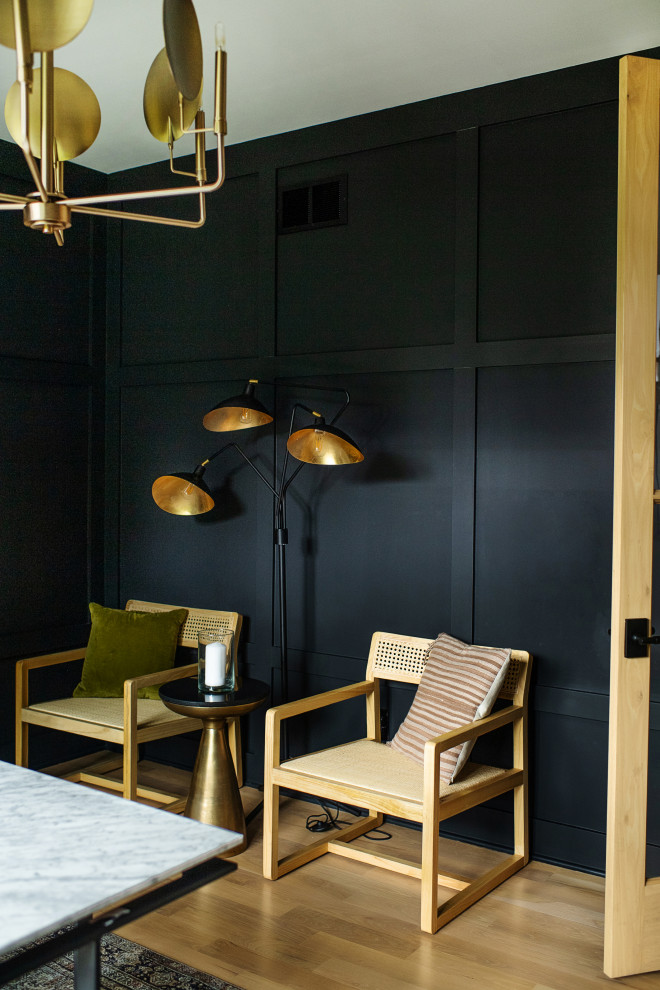 Cette image montre un bureau design avec un mur noir, parquet clair, un bureau indépendant et boiseries.