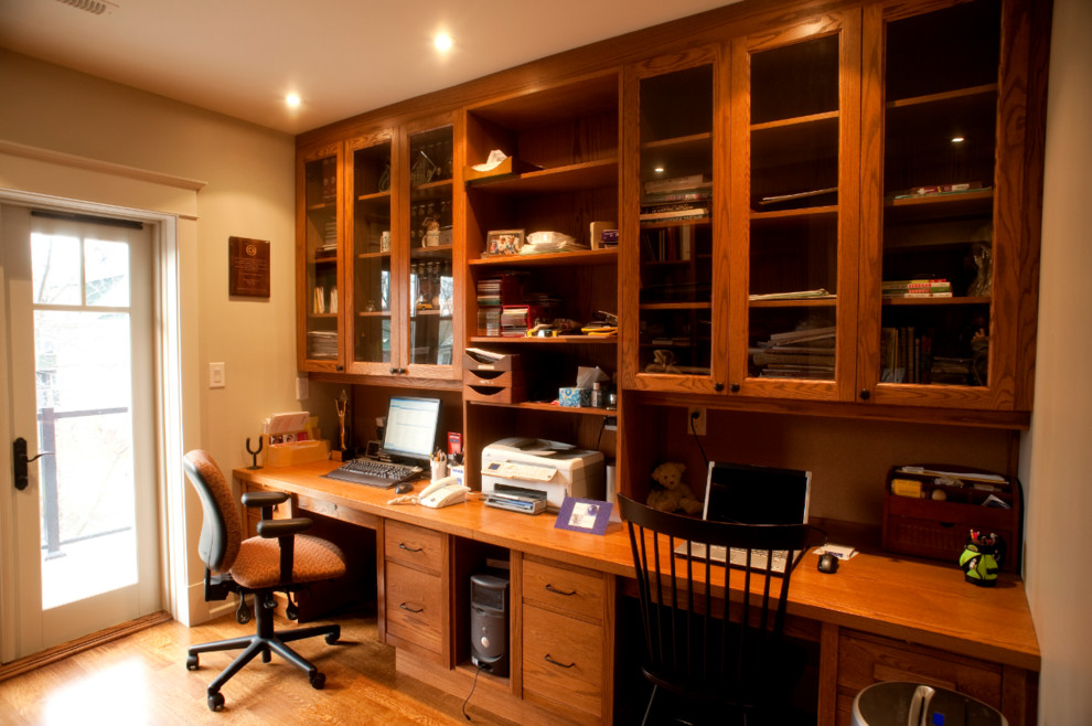 Diseño de despacho de estilo americano de tamaño medio sin chimenea con paredes beige, suelo de madera en tonos medios y escritorio empotrado
