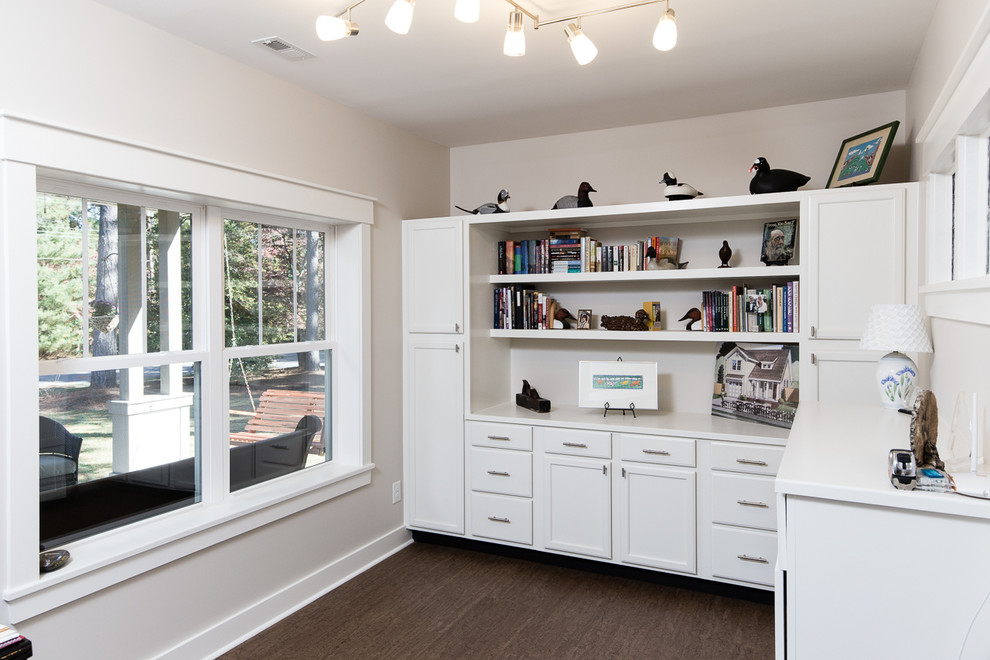 Diseño de sala de manualidades de estilo americano de tamaño medio con paredes beige, suelo de corcho y escritorio independiente