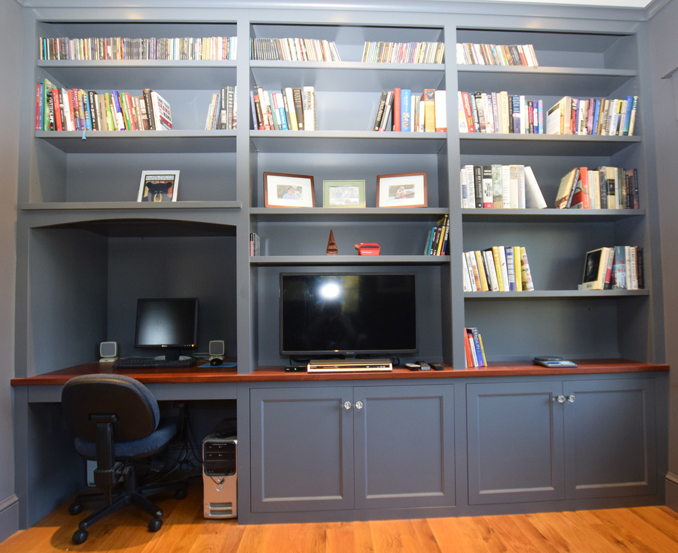 Exempel på ett mellanstort lantligt hemmabibliotek, med grå väggar, ljust trägolv och ett inbyggt skrivbord