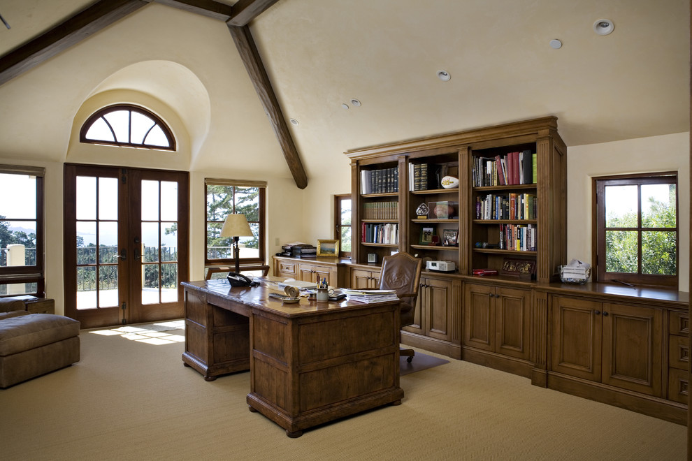 На фото: кабинет в классическом стиле с бежевыми стенами, ковровым покрытием и отдельно стоящим рабочим столом с