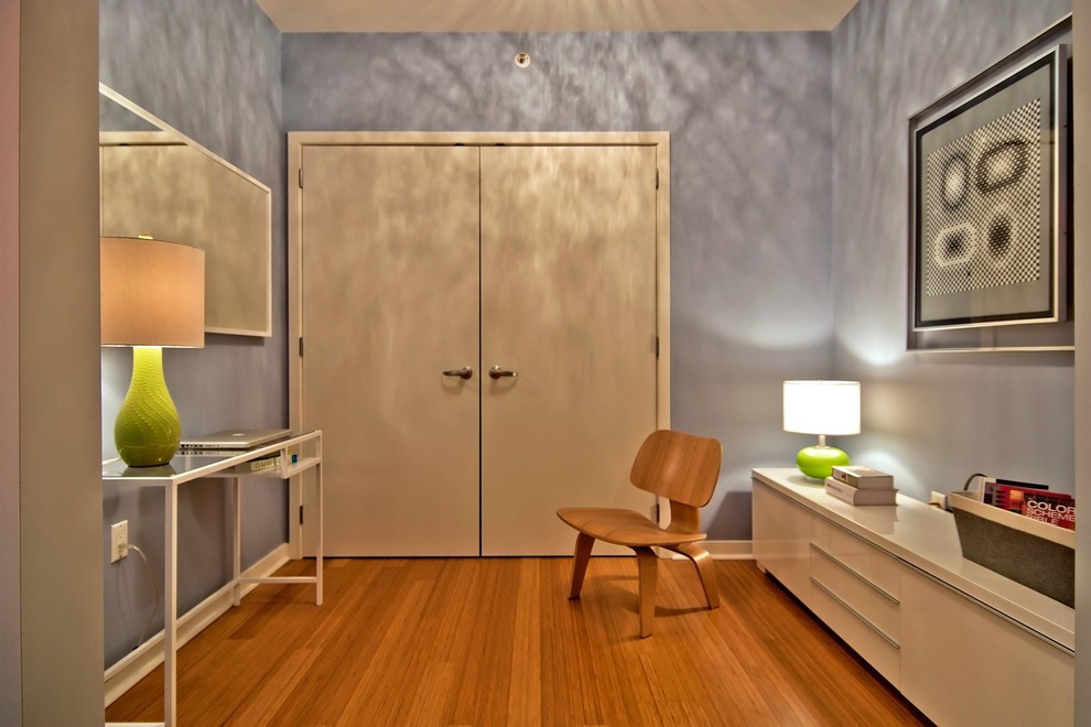 Cette image montre un petit bureau design avec un mur violet, parquet en bambou, aucune cheminée et un bureau indépendant.