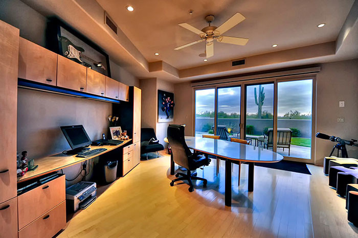 Expansive modern study in Phoenix with beige walls, medium hardwood flooring and a freestanding desk.