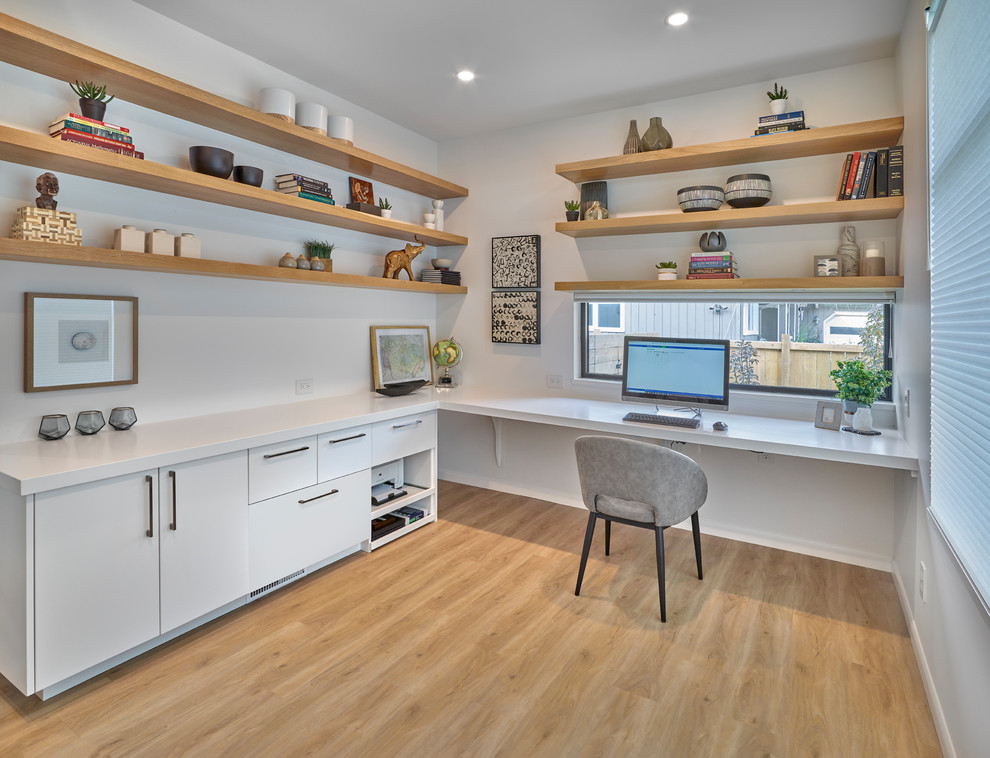 Idee per un ufficio design con pareti bianche, parquet chiaro, nessun camino e scrivania incassata