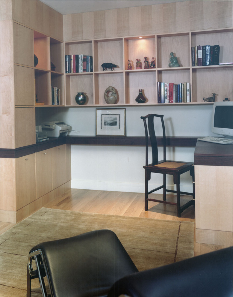 Ejemplo de despacho minimalista con paredes blancas, suelo de madera clara y escritorio empotrado