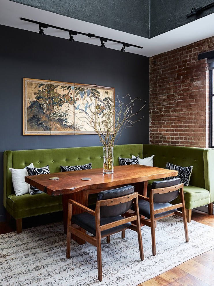 Urban dining room in San Francisco with black walls, medium hardwood flooring and brown floors.
