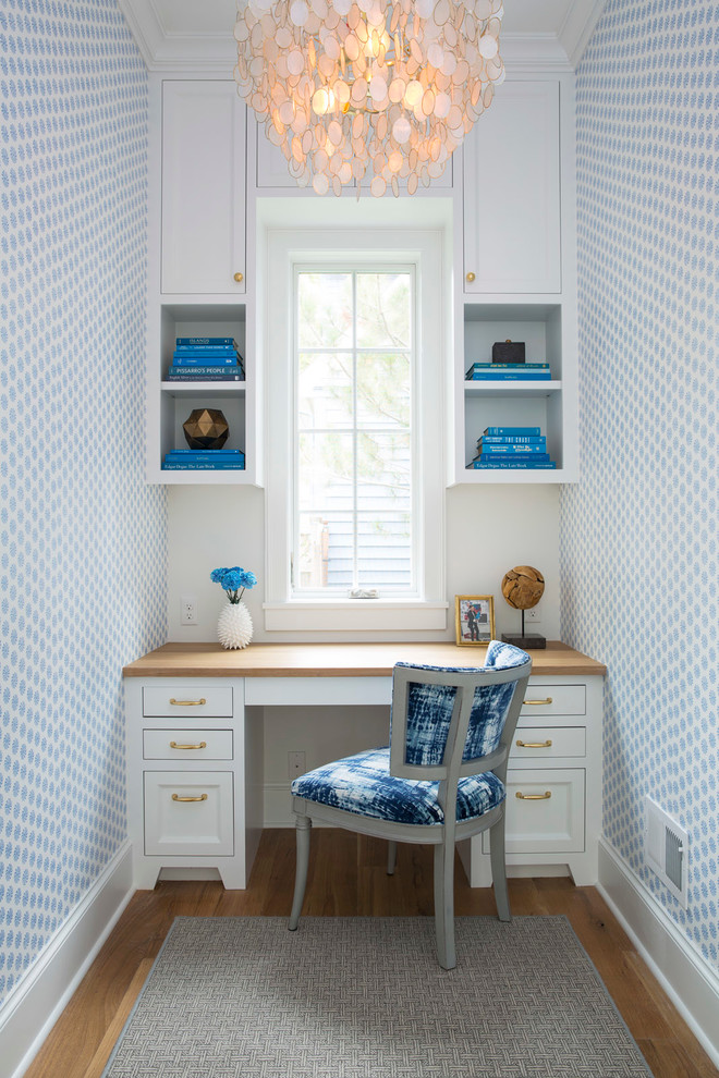 Idee per un piccolo ufficio stile marino con pareti blu, scrivania incassata, parquet chiaro, nessun camino e pavimento marrone