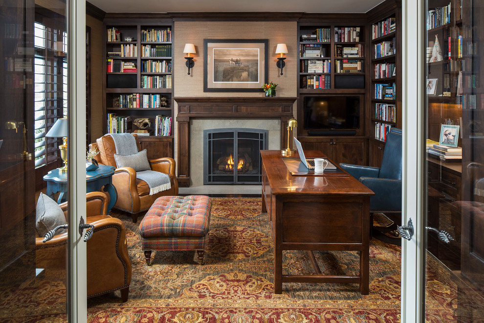 Klassisches Lesezimmer mit beiger Wandfarbe, Kamin, Kaminumrandung aus Stein und freistehendem Schreibtisch in Minneapolis