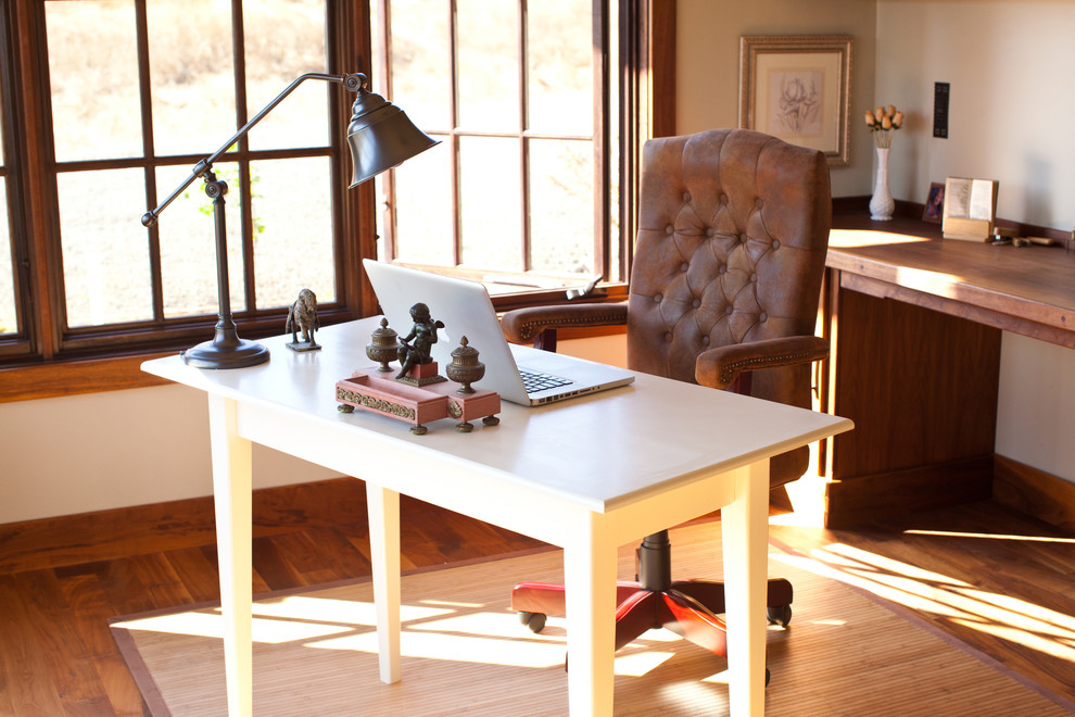 Imagen de despacho rústico grande sin chimenea con paredes beige, suelo de madera clara, escritorio independiente y suelo beige